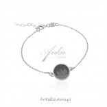 Silver bracelet with artistic drawing on a round silver plate