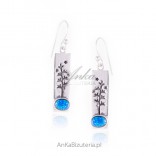 Silver earrings hanging from trees with blue opal