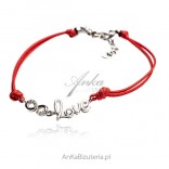 Silver bracelet with cubic zirconia on a red LOVE string
