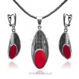 A set of silver jewelry with a red gemstone