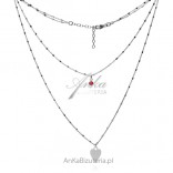 A double silver necklace with a red zircon and a heart