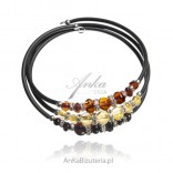 Bracelet with cognac, cherry and yellow amber and zircons on a black rubber spring