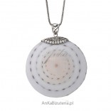 A large round pendant with silver and shells